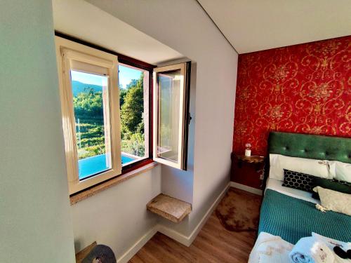 een kleine slaapkamer met 2 ramen en een bed bij Labrugia Villa Domus Casa 1 in Codeçal