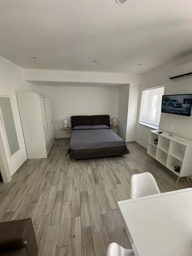 ein Schlafzimmer mit einem Bett in der Mitte eines Zimmers in der Unterkunft Mazzella Home in Ischia