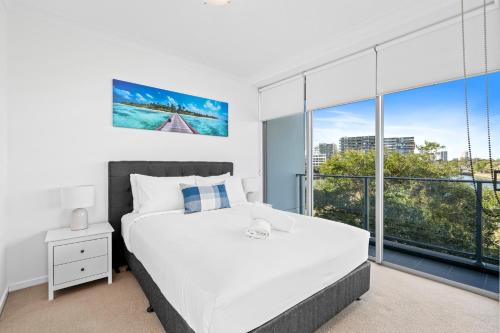 a bedroom with a bed and a large window at Harbour Quays Apartments in Gold Coast