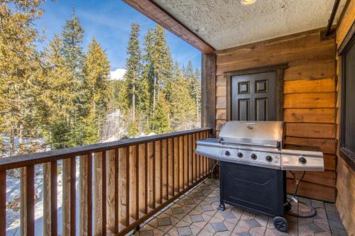 a grill on a balcony with a view of the woods at #201 Grand Lodge South Master Suite in Government Camp