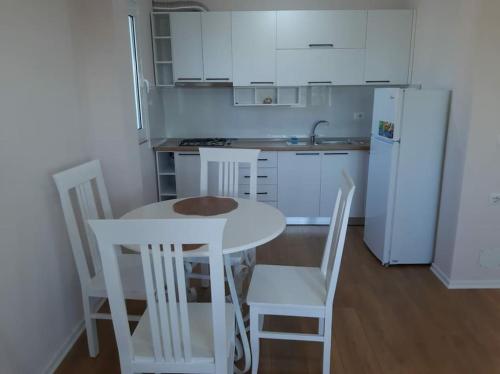 a kitchen with a table and chairs and a white refrigerator at Green Villa in Durrës