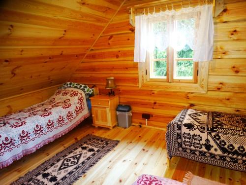 een slaapkamer met 2 bedden in een blokhut bij Chatka Rumcajsa nad Biebrzą 
