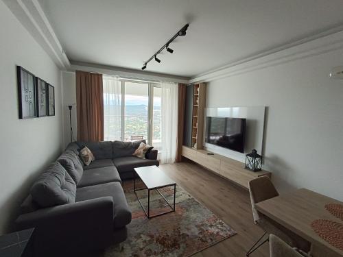ein Wohnzimmer mit einem Sofa und einem TV in der Unterkunft High Apartment in Skopje