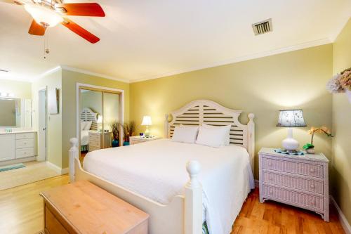 um quarto com uma cama branca e uma ventoinha de tecto em Seascape Boardwalk Villas 183 em Destin