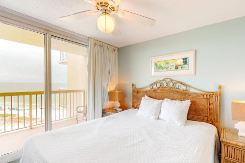 a bedroom with a bed and a balcony at Pelican Beach Resort 1717 in Destin