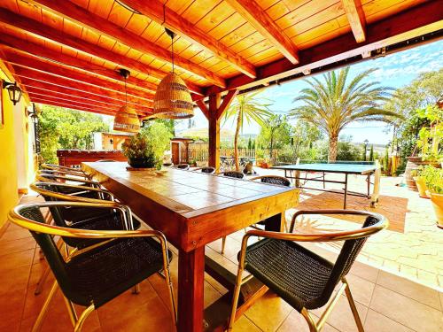 einen Holztisch und Stühle auf einer Terrasse in der Unterkunft Cortijo el Alcornocal in Málaga