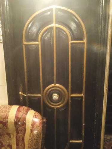 een houten deur met een gouden frame naast een bank bij فندق جاردن رويال in Caïro