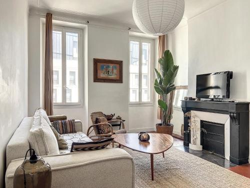 un salon avec un canapé et une cheminée dans l'établissement Appartement Marseillais - Climatisation & Spacieux - Les Frères de la Loc', à Marseille