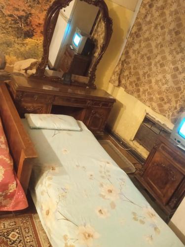 een slaapkamer met een bed, een dressoir en een spiegel bij فندق جاردن رويال in Caïro