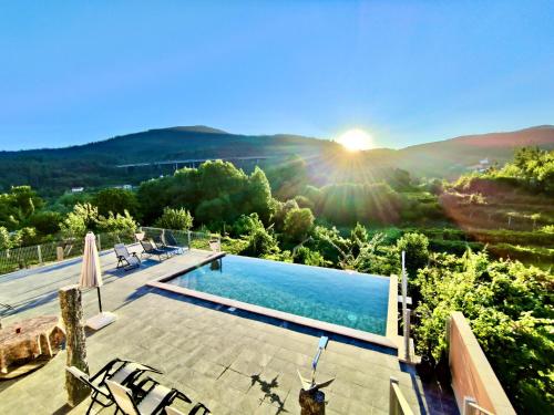 a villa with a swimming pool and the sun setting at Labrugia Domos - Nature & Pool Escape in Labruja
