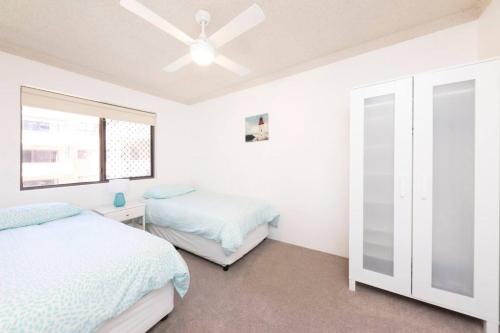 a bedroom with two beds and a ceiling fan at Breakers 11 in Forster