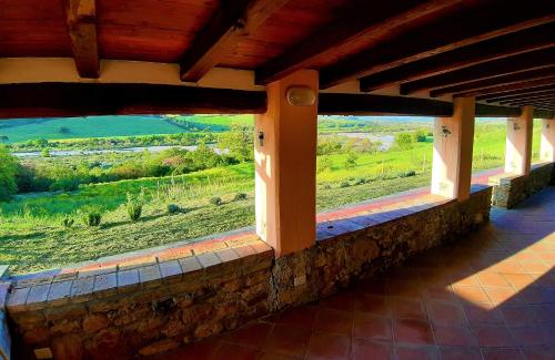 a room with a window with a view of a field at Villa Saturnia in Saturnia