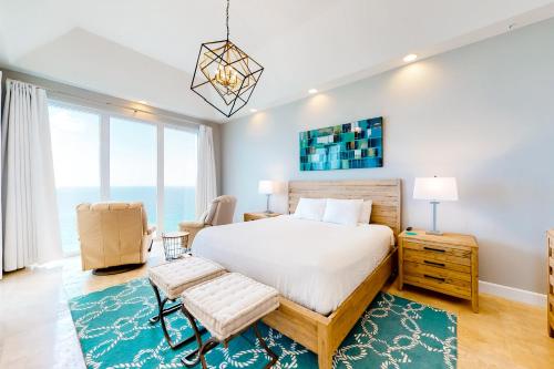 ein Schlafzimmer mit einem Bett und einem Stuhl in der Unterkunft Caribbean Resort 1801 - Penthouse in Navarre