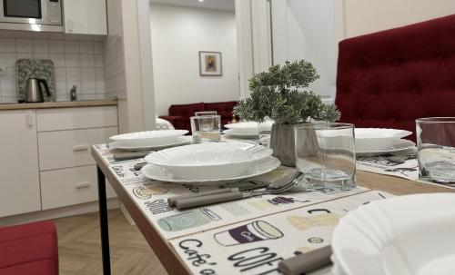 une table avec des assiettes et des verres au-dessus dans l'établissement La Dolce Vita Apartments Sarajevo, à Sarajevo