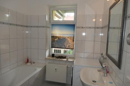 a white bathroom with a tub and a sink and a bath tubermott at Ländlicher Rückzugsort im Herzen von Mühlhausen in Mühlhausen