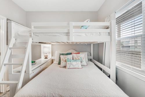 a white bunk bed in a small room with a bunk bed in a bedroom at Baywatch F2 in Pensacola Beach