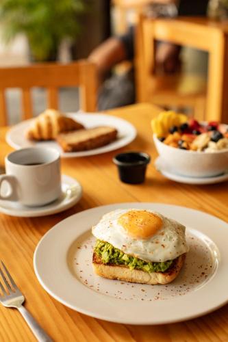 ein Tisch mit Tellern voller Essen und einem Ei darauf in der Unterkunft Che Puerto Escondido Hostel & Bar Adults Only in Puerto Escondido