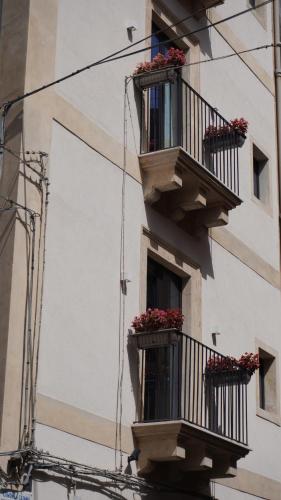 a building with two balconies with flowers on them at VICOLO SAN GAETANO -luxury rooms- in Catania