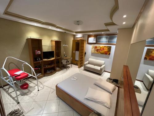 um quarto com uma cama, uma cadeira e uma secretária em Shampoo Prime Motel em Brusque