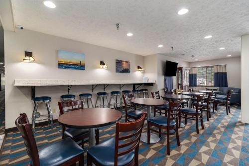 a restaurant with tables and chairs and a bar at Microtel Inn and Suites Manistee in Manistee