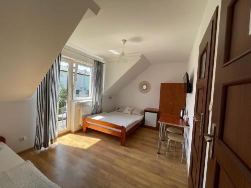 - une chambre avec un lit, un bureau et une fenêtre dans l'établissement Willa Filip, à Władysławowo