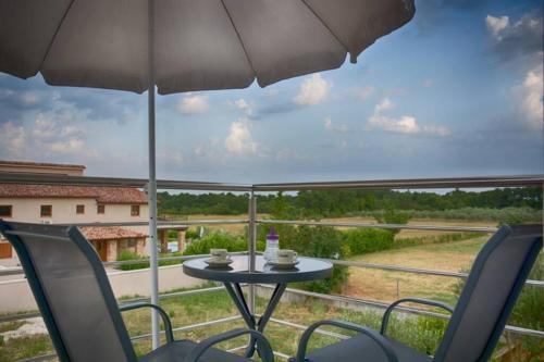 a patio with a table and chairs and an umbrella at Apartment Vacation Rental Near Pula in Loborika