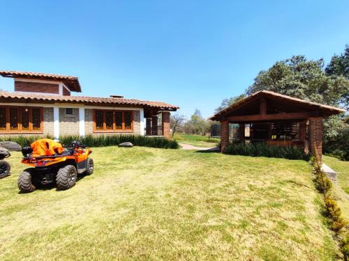 a tractor parked in a yard in front of a house at cabaña el rio la grande in Zacatlán
