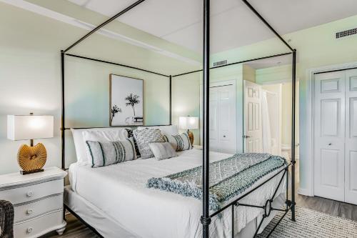une chambre avec un lit à baldaquin avec un miroir dans l'établissement Pelican Isle 606, à Fort Walton Beach