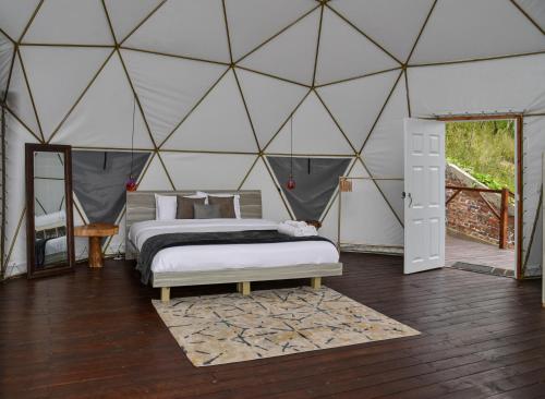 a bedroom with two beds in a dome tent at Golden Glamping in Guatavita