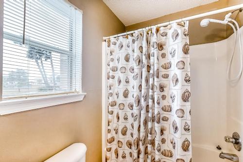 a bathroom with a shower curtain and a toilet at Sunset Harbour Villas 1-111 in Navarre