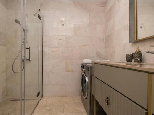 ein Bad mit einer Dusche und einer Waschmaschine in der Unterkunft Divan Residence at G tower Apartment in Istanbul
