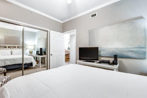 a bedroom with a bed and a flat screen tv at South Harbour 04C in Pensacola Beach