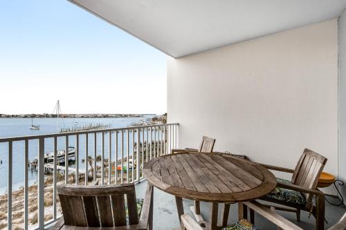 a table and chairs on a balcony with a view of the water at South Harbour 04C in Pensacola Beach