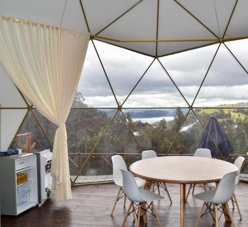 a room with a table and chairs in a tent at Golden Glamping & Suites in Guatavita