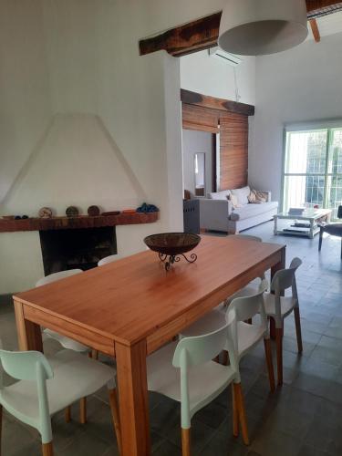 una mesa de madera y sillas en la sala de estar. en Casa en Camino del cuadrado Sierras de Córdoba en Río Ceballos