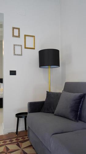 a living room with a couch and a lamp at VICOLO SAN GAETANO -luxury rooms- in Catania