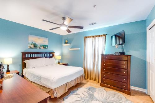 1 dormitorio con 1 cama y vestidor con TV en Veranda 101, en Fort Walton Beach