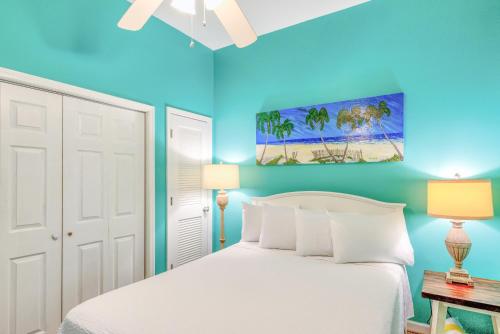 a bedroom with a white bed and blue walls at Windemere 0302 in Perdido Key