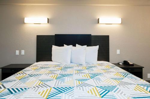 a bed in a hotel room with a colorful bedspread at Motel 6-Baytown, TX - Garth Rd in Baytown