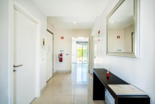 einen Flur mit einer schwarzen Theke und einem Spiegel in der Unterkunft Fabulous 2 bedroom apartment Pine Hills in Vilamoura