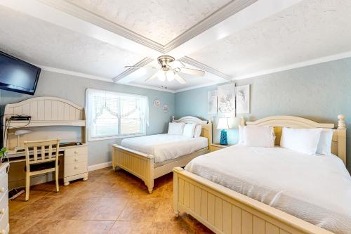 a bedroom with two beds and a desk and a window at Surf Dweller 704 in Fort Walton Beach