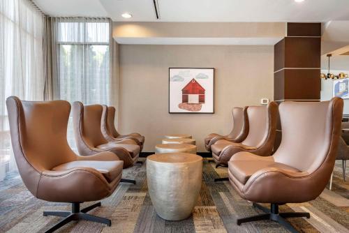 una sala de espera con sillas de cuero y una mesa en Cambria Hotel Madison East en Madison
