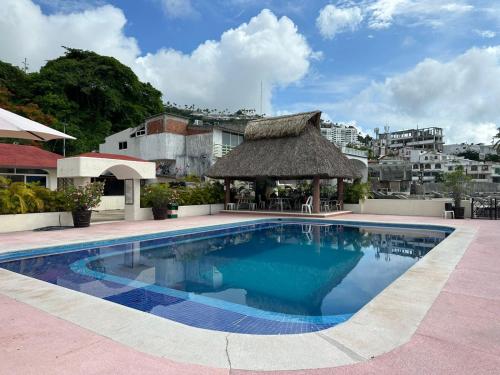 einen Pool mit Pavillon neben einem Gebäude in der Unterkunft BRISAS GUITARRON in Acapulco