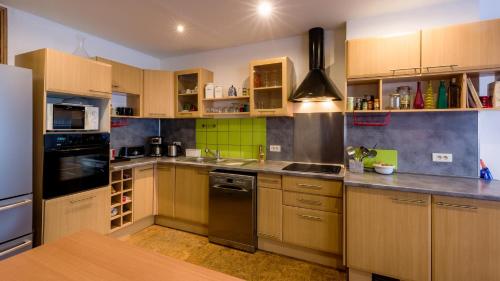 uma cozinha com armários de madeira e electrodomésticos de aço inoxidável em Loft Berriat/Ampère em Grenoble