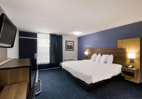 a hotel room with a bed and a flat screen tv at SureStay Plus by Best Western Pigeon Forge in Pigeon Forge