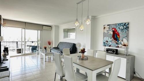 a dining room and living room with a table and chairs at Apartamento con vistas a mar y canal. Empuriabrava in Empuriabrava