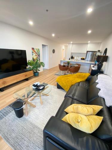 a living room with a black leather couch at Sweet home 2BR/2BA/2CAR Denman in Weston Creek