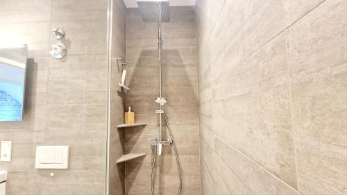 a shower with a glass door in a bathroom at Industrie Stil Apartment unweit vom See in Losheim