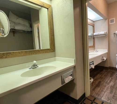 a bathroom with a sink and a mirror at Baymont by Wyndham West Plains in West Plains