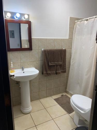 a bathroom with a sink and a toilet and a mirror at Cocomarindo Condo #72 in Coco